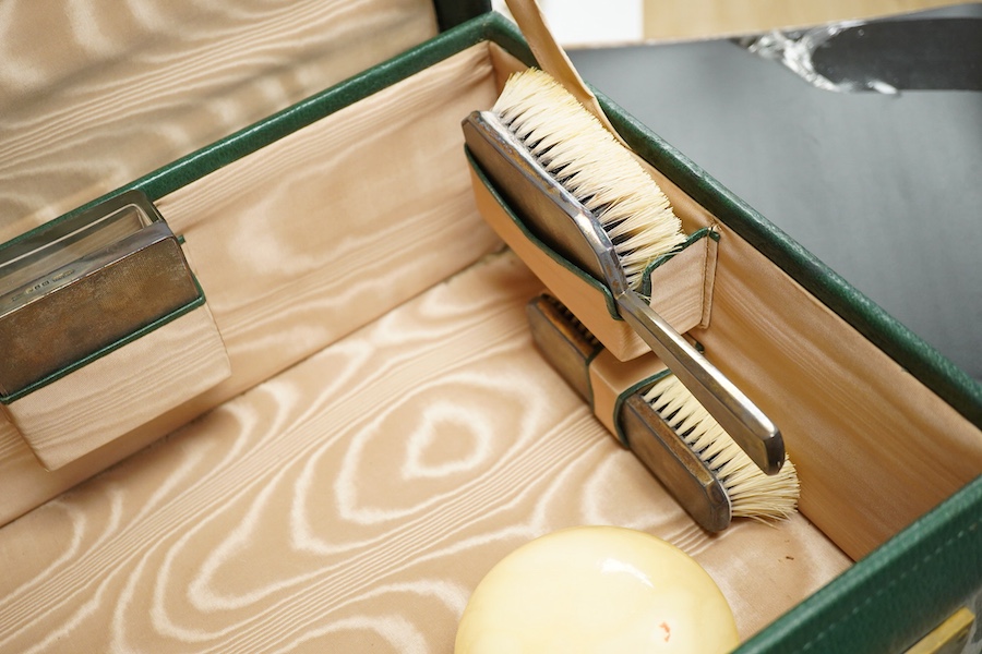 Two fitted travelling vanity cases, one with eight silver mounted toilet jars etc. by Asprey & Co, London, 1938, the other with seventeen silver mounted items, Thomas Jones Watson, London, 1911(incomplete).